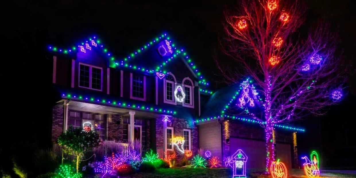 House decorated with colorful Halloween lights at night.