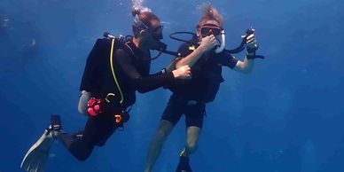a beginner scuba diver with his instructor during his discover scuba diving in Koh Tao Thailand 