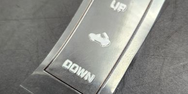 Metal button panel with up and down labels and a shoe icon.