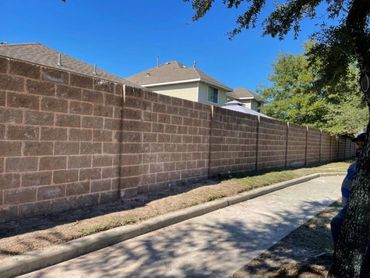 Minimalist dark fence enclosing a residential green garden