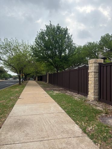 Elegant dark brown garden fence bordering a fresh green lawn
