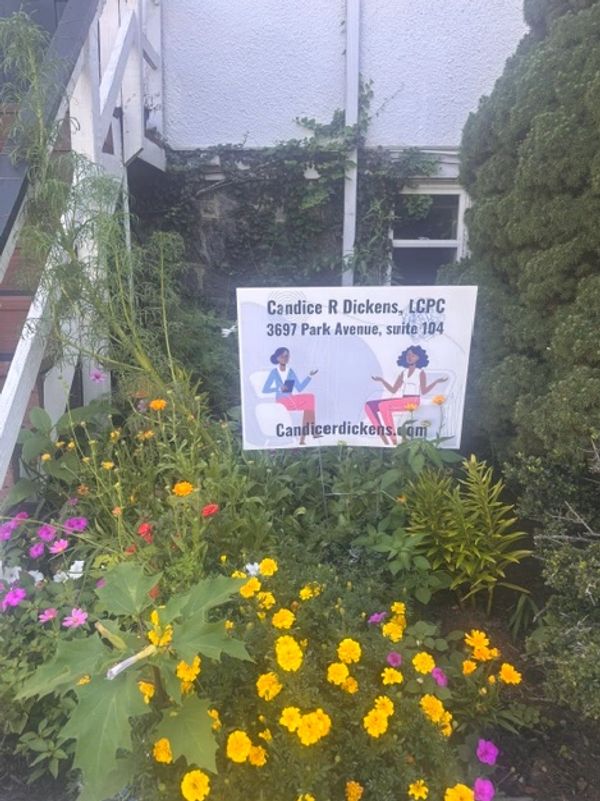 Sign for Candice R Dickens, LCPC, in a flower garden.