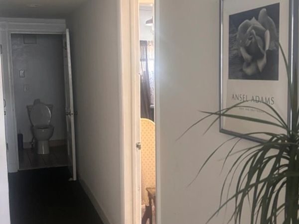 Hallway view showing an open bathroom door with a toilet.