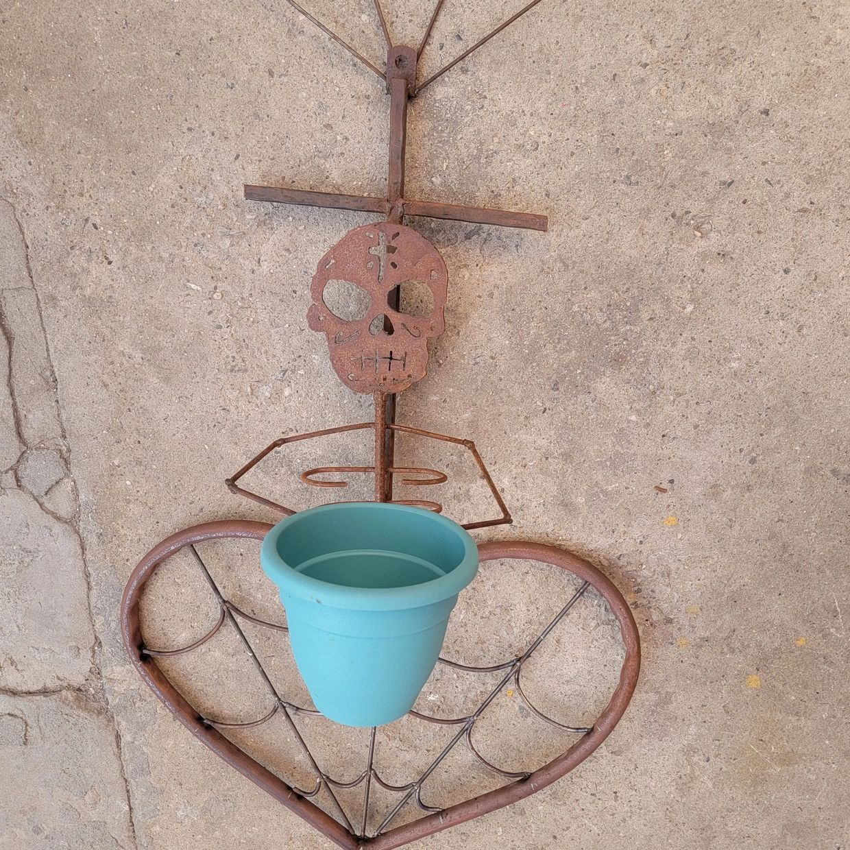 Raw Sacred Heart with Calavera holding a pot for a plant raw steel rusty
