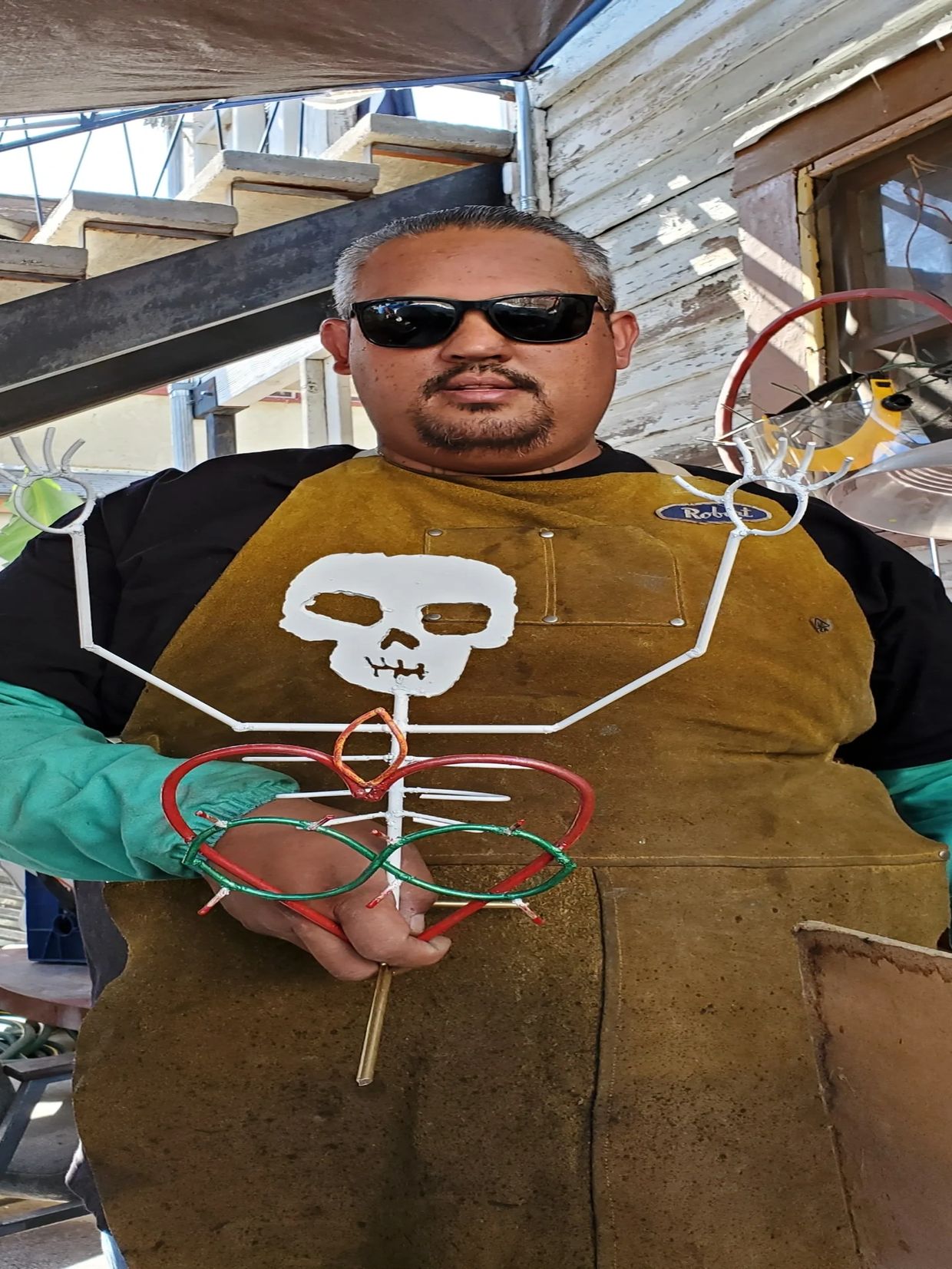Robert Collado at the workshop with metal skeleton figure. Sacred heart 