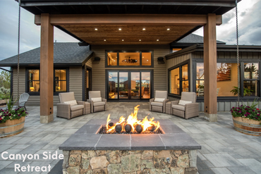 lit outdoor fire pit looking into the house's grand living room