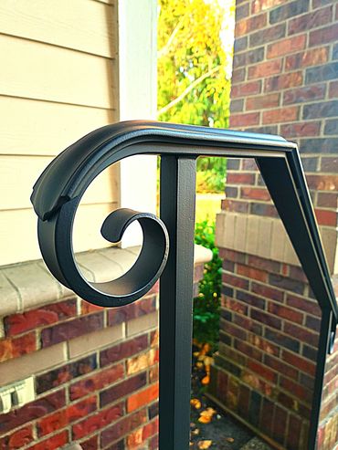 Hand-forged decorative wrought iron hand railing with scrollwork by Primal Forge blacksmith shop