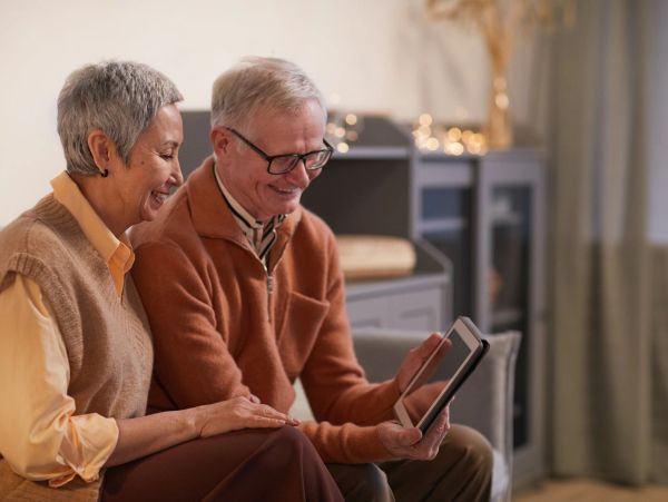 Elderly couple enjoying a tablet together at home.