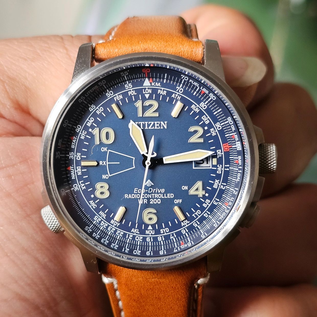 Close-up of a Citizen Eco-Drive wristwatch with a brown leather strap.
