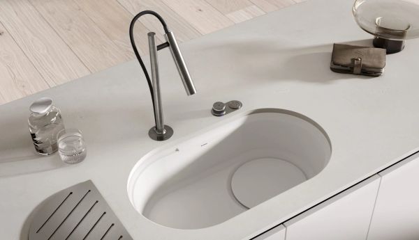 Modern minimalist kitchen sink with sleek faucet.