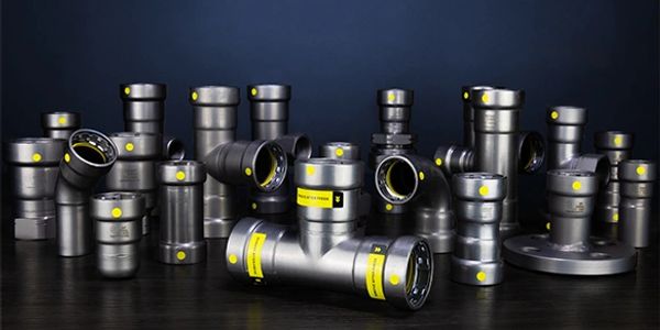 Collection of metal pipe fittings with yellow labels.