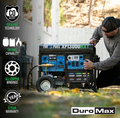 Man operating a DuroMax XP13000HXT tri-fuel generator outdoors.