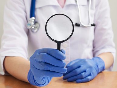 Medical provider holding a magnifying glass image.