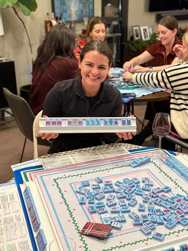 Young woman smiling after winning Mahjong at a private mahjong event in Charlotte