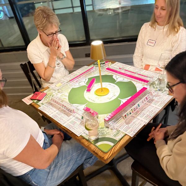 Close up of a group of women playing mahjong at a table at a mahjong event in Charlotte