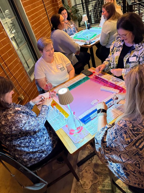 Group of mahjong players playing a game of mahjong at a charlotte mahjong event in south end