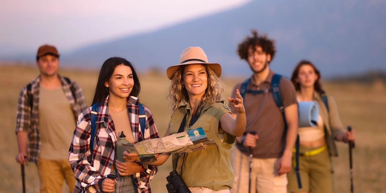 Group of friends hiking and navigating with a map outdoors.