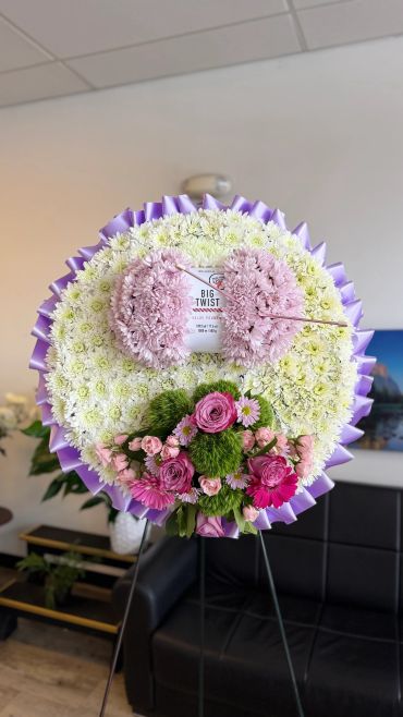 A beautiful round floral arrangement with pink and white flowers.