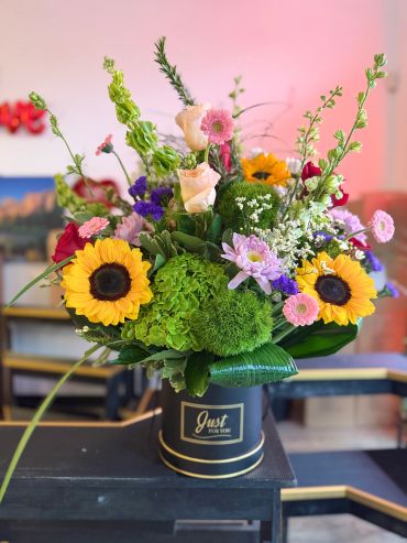 Bright sunflower bouquet in a black vase.