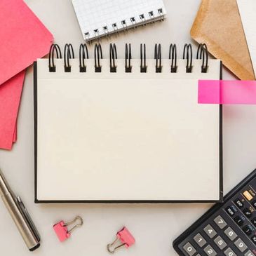 A White Color Wire Bound Notebook With a Calculator