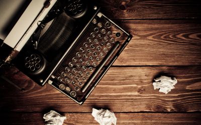 Vintage typewriter with crumpled paper on wooden surface.