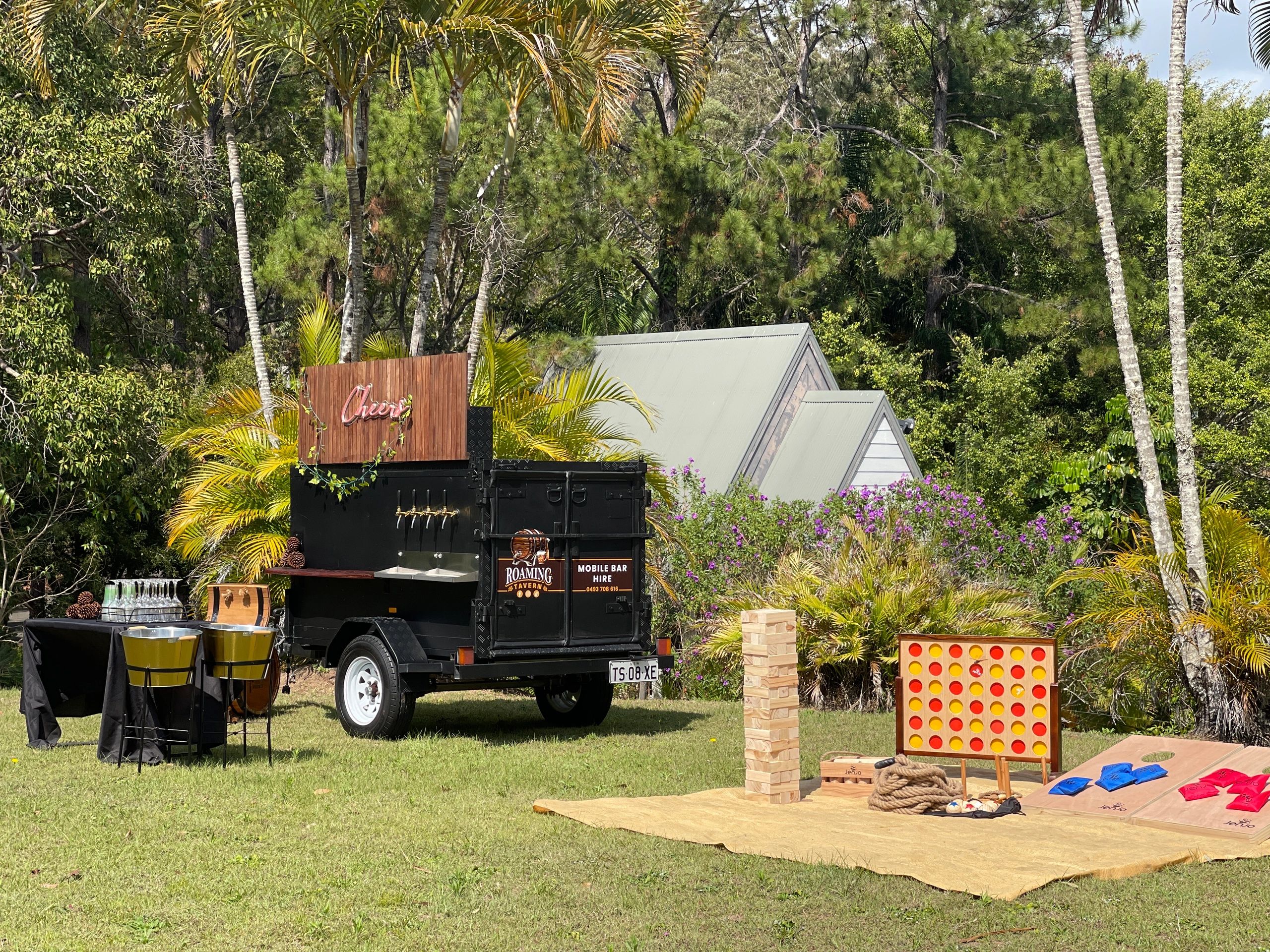 Mobile bar with: wine buckets, cooler, and yard games in an outdoor setting for outdoor events. 