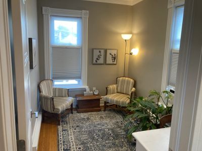 Cozy sitting area with two striped chairs and a patterned rug.
