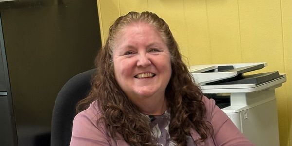 Smiling woman sitting in an office chair.
