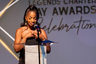 A woman giving a speech at an awards ceremony.