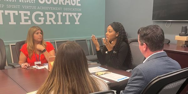 Four professionals engaged in a discussion in a conference room.