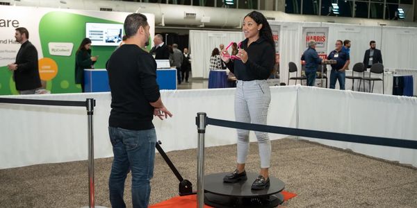 Two people interacting at a technology exhibit.