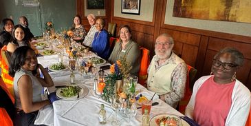 Group of friends enjoying a festive dinner around a long table.