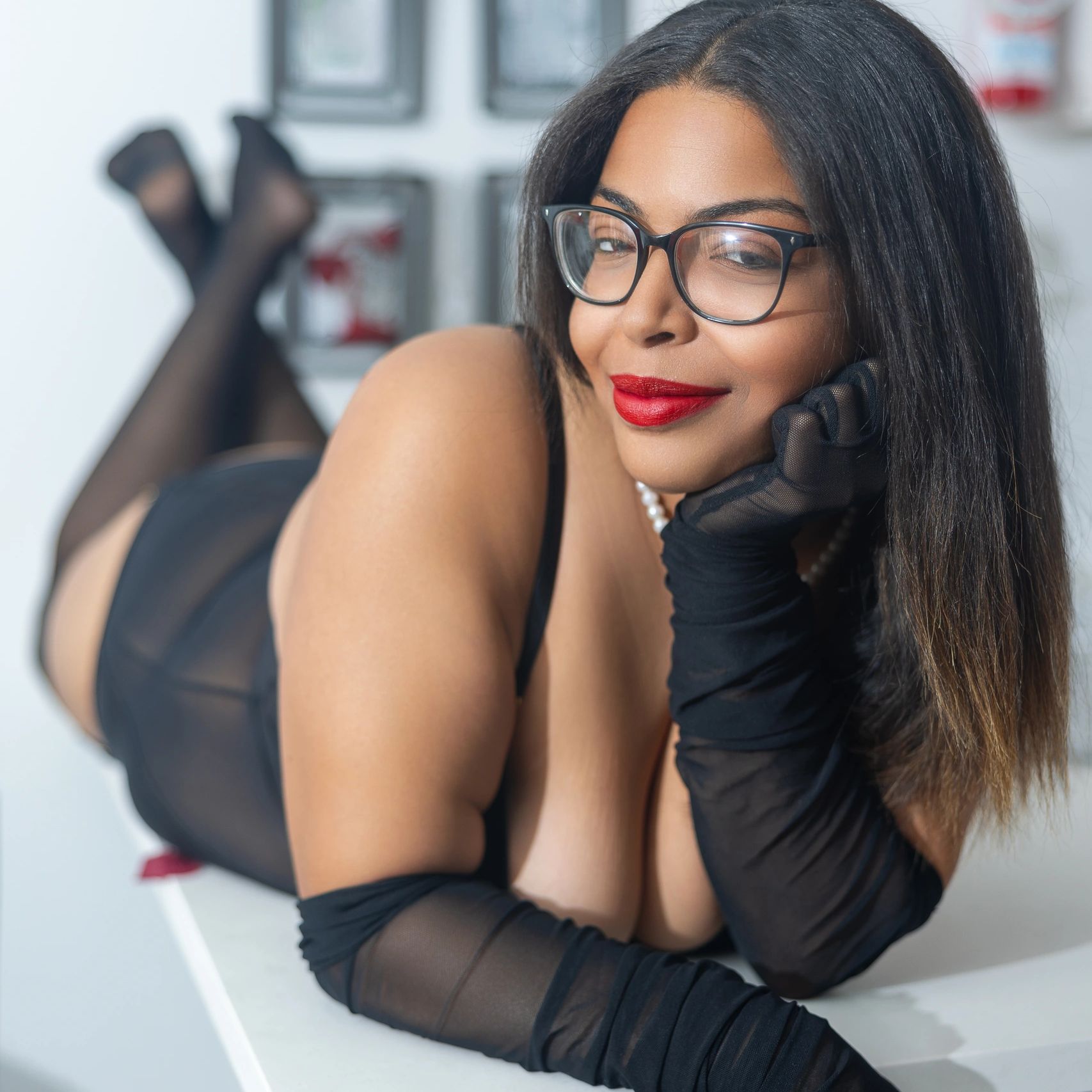 Smiling woman wearing glasses and black gloves.