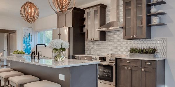 Modern kitchen with dark wood cabinets and white countertops.