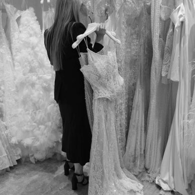 Woman selecting a wedding dress in a bridal shop.