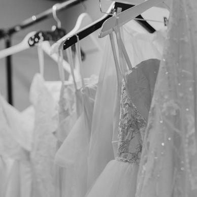 Close-up of wedding dresses hanging on a rack.
