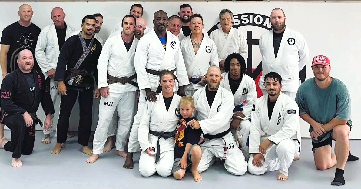 Group of martial artists in gi posing for a photo.