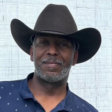 Man wearing a cowboy hat and a blue shirt.