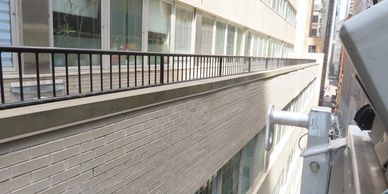Alleyway between two buildings with a security camera on the right.