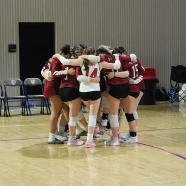 Volleyball team in a group huddle before a game.