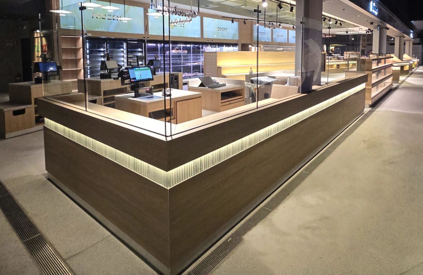 Empty modern checkout counter area with monitors and glass dividers.
