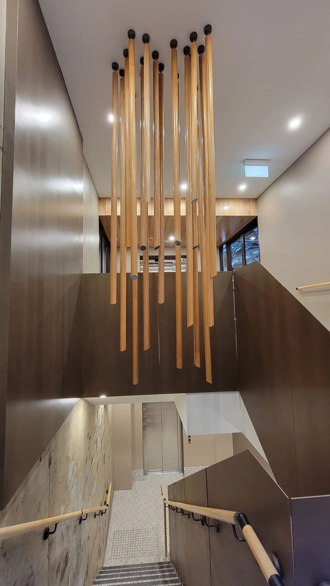 Modern staircase with hanging wooden rods.