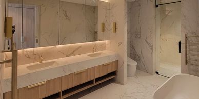 Modern bathroom with marble walls and countertops.