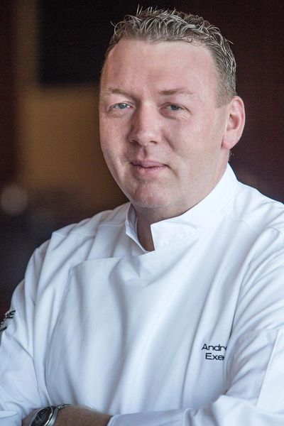 Portrait of a confident chef in a white uniform.