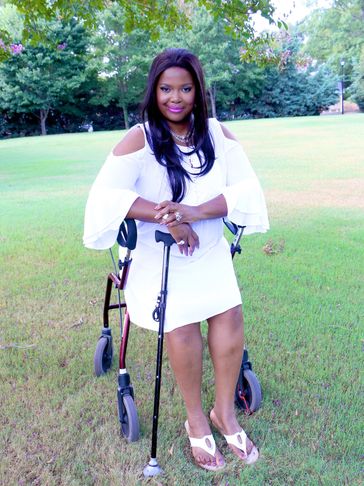 Woman in white dress with walker and cane outdoors.