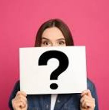 Woman holding a question mark sign in front of her face.