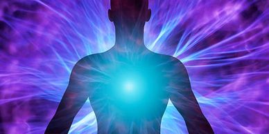 Silhouette with radiant energy emanating from the chest in vibrant purple and blue hues.