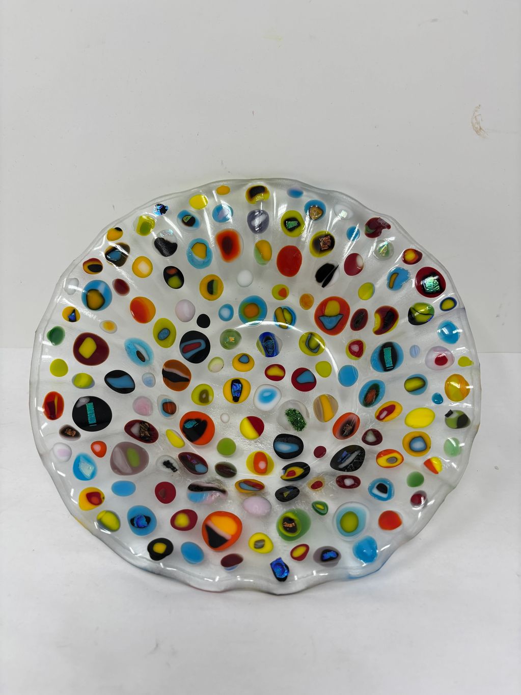 Multicolored glass bowl with circular patterns.