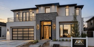 Modern two-story house with large windows and a front yard.