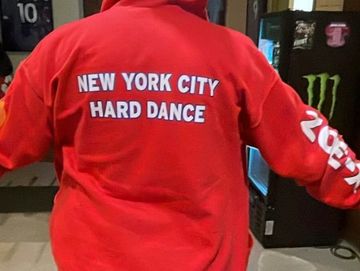 Person wearing a red hoodie with 'New York City Hard Dance' on the back.